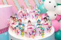 Decorative toys for children`s parties, dolls lol on a white table, on the background of balloons.