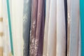 Decorative transparent curtains with floral and ornamental patterns, multicolored textile samples hanging vertically on the Royalty Free Stock Photo
