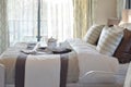 Decorative tray with book and tea set on the bed in modern bedroom Royalty Free Stock Photo