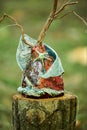 Decorative vases art objects in marine style on tree stump at outdoor art exhibition in green forest