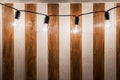 Decorative vintage edison light bulbs against striped wooden wall background. Royalty Free Stock Photo