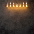 Decorative vintage lightbulbs on dark concrete background