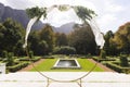 Decorative wedding arch and pond in sunny garden Royalty Free Stock Photo