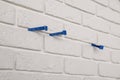 Decorative white bricks with tile leveling system on wall, closeup Royalty Free Stock Photo