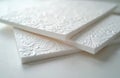 Decorative white foam panels with floral patterns are stacked. These embossed sheets offer elegant texture for interior design Royalty Free Stock Photo