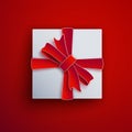 Decorative white gift box isolated on red background. Red bow, ribbon festive element for holiday design, christmas greeting card Royalty Free Stock Photo