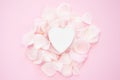 Decorative white heart with flower petals on a pink background. Flat lay Royalty Free Stock Photo