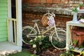 Decorative white vintage bicycle against brick wall. Old bicycle parked against a stone wall in garden. Street decoration backyard Royalty Free Stock Photo
