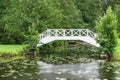 Decorative white wooden bridge over small pond in park Royalty Free Stock Photo