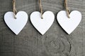 Decorative white wooden Christmas hearts on grey rustic wooden background with copy space.