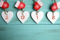 Decorative white wooden Christmas hearts and red mittens with 2018 numbers on blue wooden background with copy space.Happy New Yea Royalty Free Stock Photo