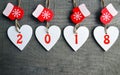 Decorative white wooden Christmas hearts and red mittens with 2018 numbers on wooden background with copy space.Happy New Year 201 Royalty Free Stock Photo