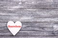 Decorative white wooden heart on grey wooden background with lettering Love Italian. Royalty Free Stock Photo