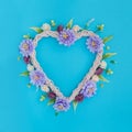 Decorative wicker heart with artificial flowers on a blue background Royalty Free Stock Photo