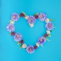 Decorative wicker heart with artificial flowers on a blue background Royalty Free Stock Photo