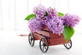 Decorative wooden carriage full of lilacs