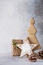 Decorative wooden Christmas tree and star, cone and fabric wrapped gifts, on a light background. Zero waste concept