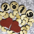 2019 on decorative wooden elements, wooden hearts and two textile red hearts on snowflake background.