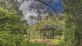 A decorative wooden gazebo with benches and a thatched roof Royalty Free Stock Photo