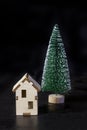 Decorative wooden model house with a Christmas tree on a black background Royalty Free Stock Photo