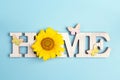 Decorative word Home with butterflies and sunflower on blue back