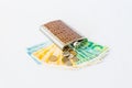 Decoratively decorated with a crocodile skin a flask for alcohol lies on a stack of mixed banknotes and coins of new Israeli sheke Royalty Free Stock Photo