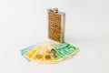 Decoratively decorated with a crocodile skin a flask for alcohol stands near a stack of mixed banknotes and coins of new Israeli s Royalty Free Stock Photo