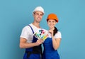 Decorators man and woman in hardhats holding color swatches, ready for repair