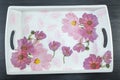 Decoupage decorated tray with flower pattern against black wood