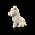 Antique figurine of a dog on a black isolated background. puppy toy. Royalty Free Stock Photo