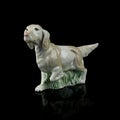Antique figurine of a dog on a black isolated background. puppy toy. Royalty Free Stock Photo