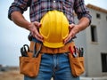 Dedicated Construction Worker Holding Hard Hat with Tools in an Active Worksite Royalty Free Stock Photo