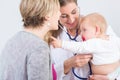 Dedicated female physician holding a cute baby girl in her arms