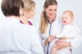 Dedicated female physician holding a cute baby girl in her arms