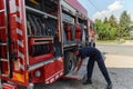A dedicated firefighter preparing a modern firetruck for deployment to hazardous fire-stricken areas, demonstrating