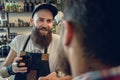 Dedicated hairstylist drinking coffee with his customer and friend