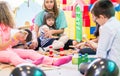 Dedicated kindergarten teacher holding a shy girl while watching