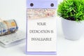 Dedication Card Displayed Next to Greenery and Cash With Calculator on Desk Highlighting Value of Efforts Royalty Free Stock Photo
