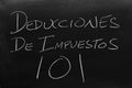 Deducciones De Impuestos 101 On A Blackboard. Translation: Tax Deductions 101