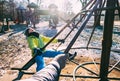 Deep autumn on child playground. Mom turns the boy on the carousel.