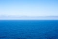 Deep blue empty ocean seascape with clouds on horizon