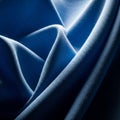 Deep blue fabric with a smooth texture and subtle sheen is artistically draped, creatin Royalty Free Stock Photo
