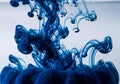 Deep blue ink swirling elegantly through water, creating intricate patterns and fluid motion Royalty Free Stock Photo