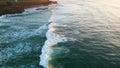 Deep blue ocean foaming rolling on rocky shore. Aerial view surfers waiting wave Royalty Free Stock Photo