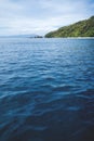 Deep blue ocean waves with lush green island and rocks in Palawan, Philippines Royalty Free Stock Photo