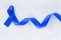 Deep blue ribbon curl on white fabric with copy space. Colorectal Cancer Awareness, Colon cancer of older person and world