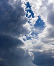 Blue sky coming out from behind dark blue stormy clouds Royalty Free Stock Photo