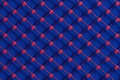 Deep blue upholstery with red button accents and diamond pattern Royalty Free Stock Photo