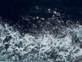 Deep blue water splash from boat trace
