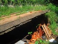 DEEP CAVE-IN UNDER THE SURFACE OF A SLOPED TARRED ROAD